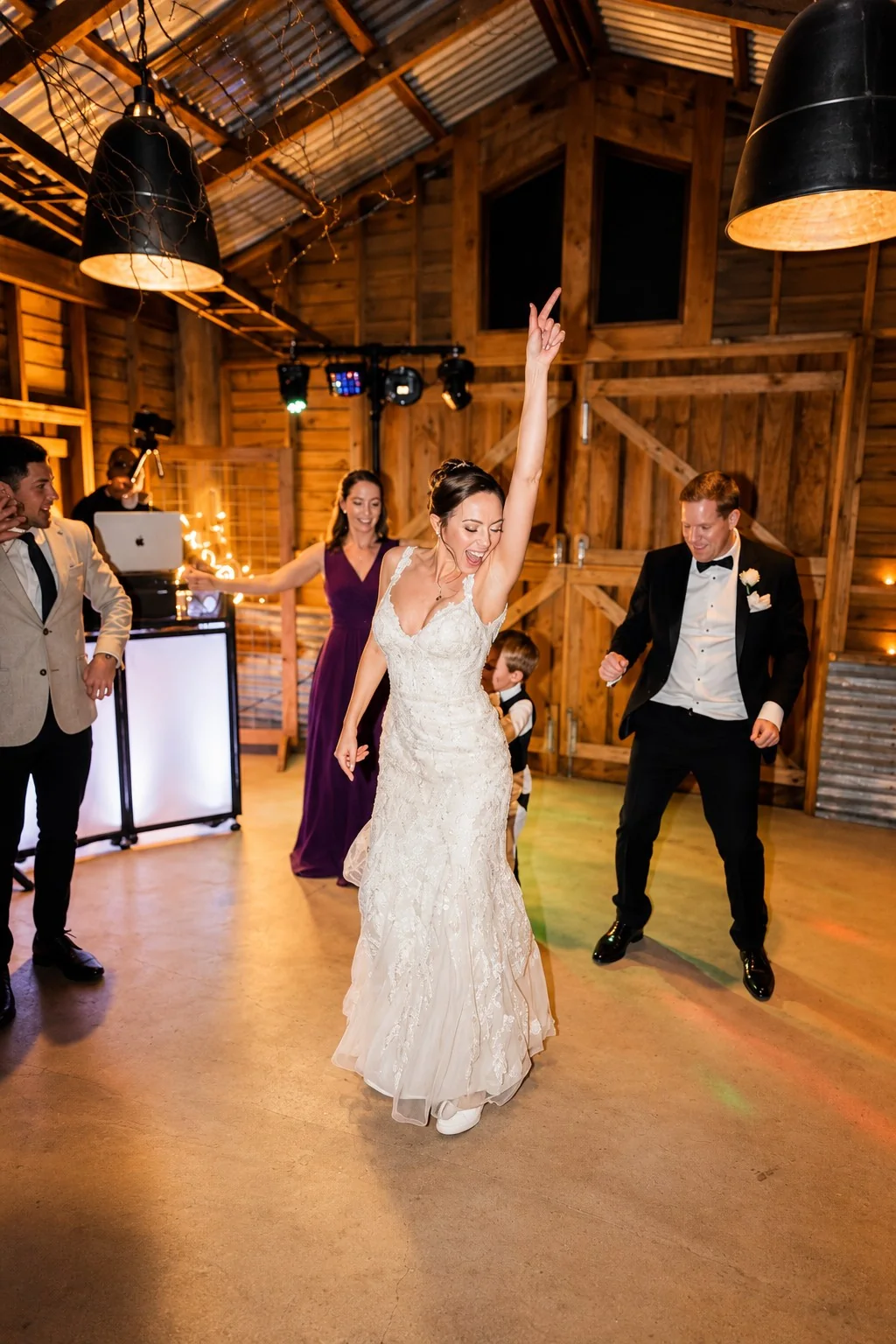 Bride dancing with guests at a rustic wedding reception