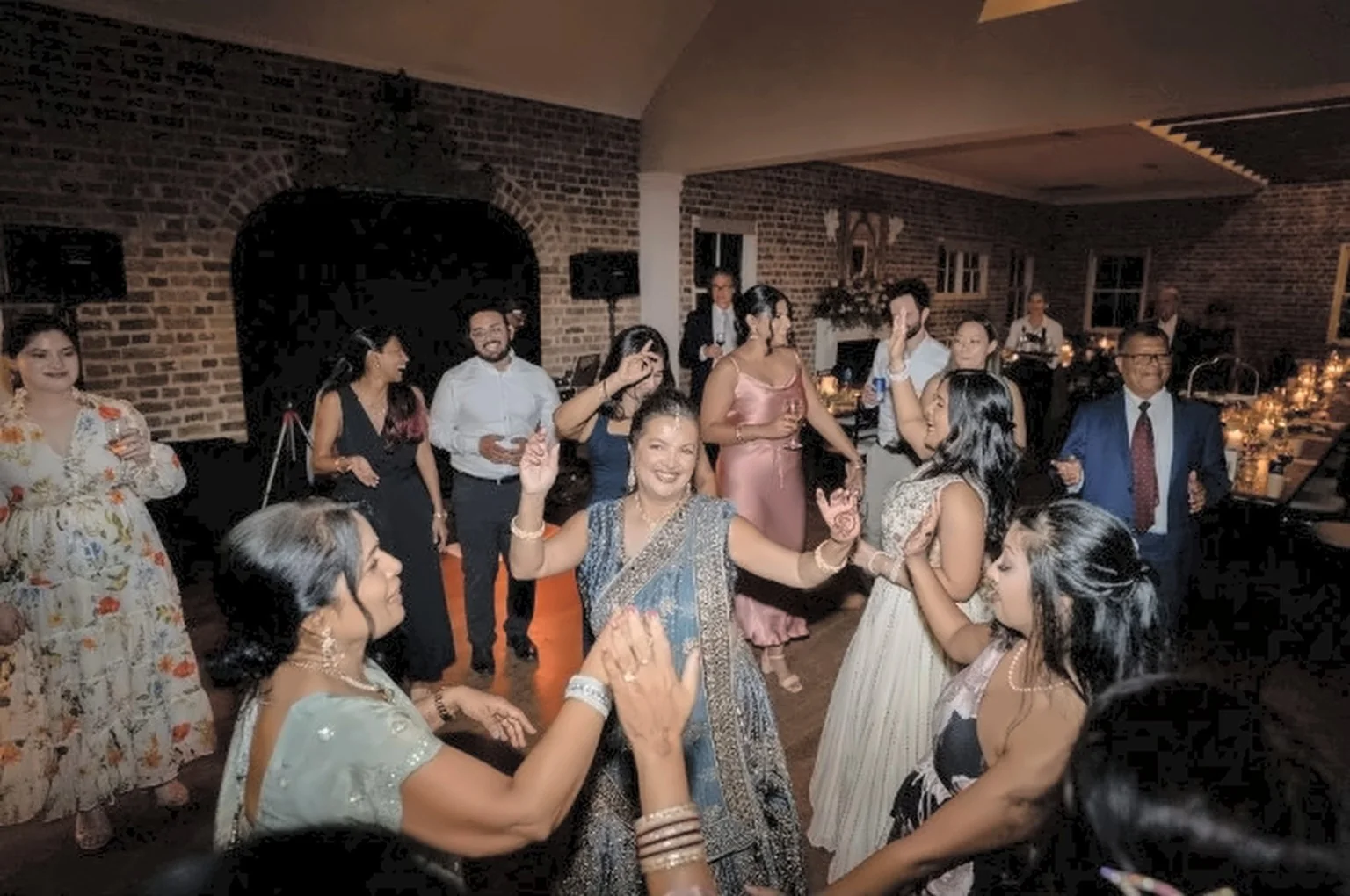 Wedding guests celebrating and dancing in a rustic brick reception venue